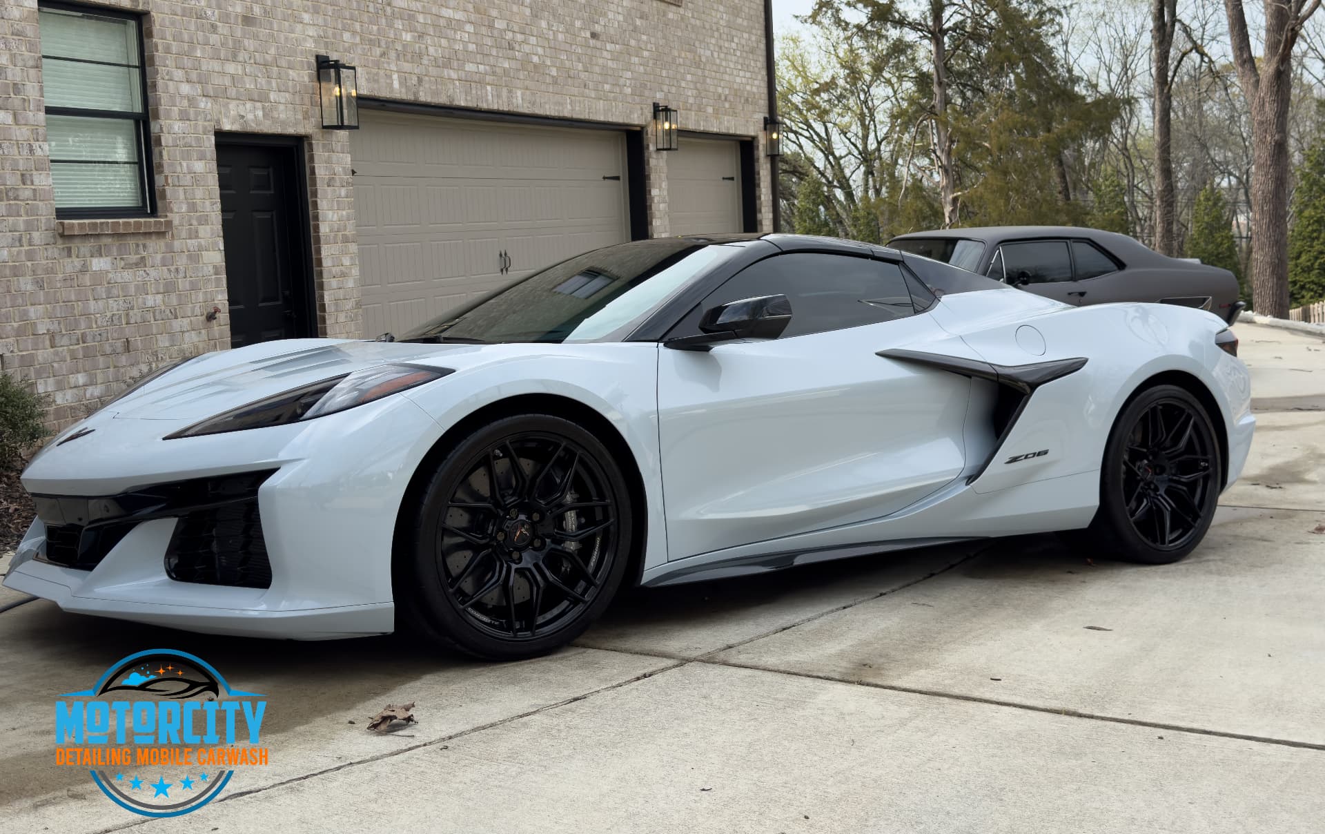 Mobile car detailing on a white Chevrolet Corvette Z06 in a driveway