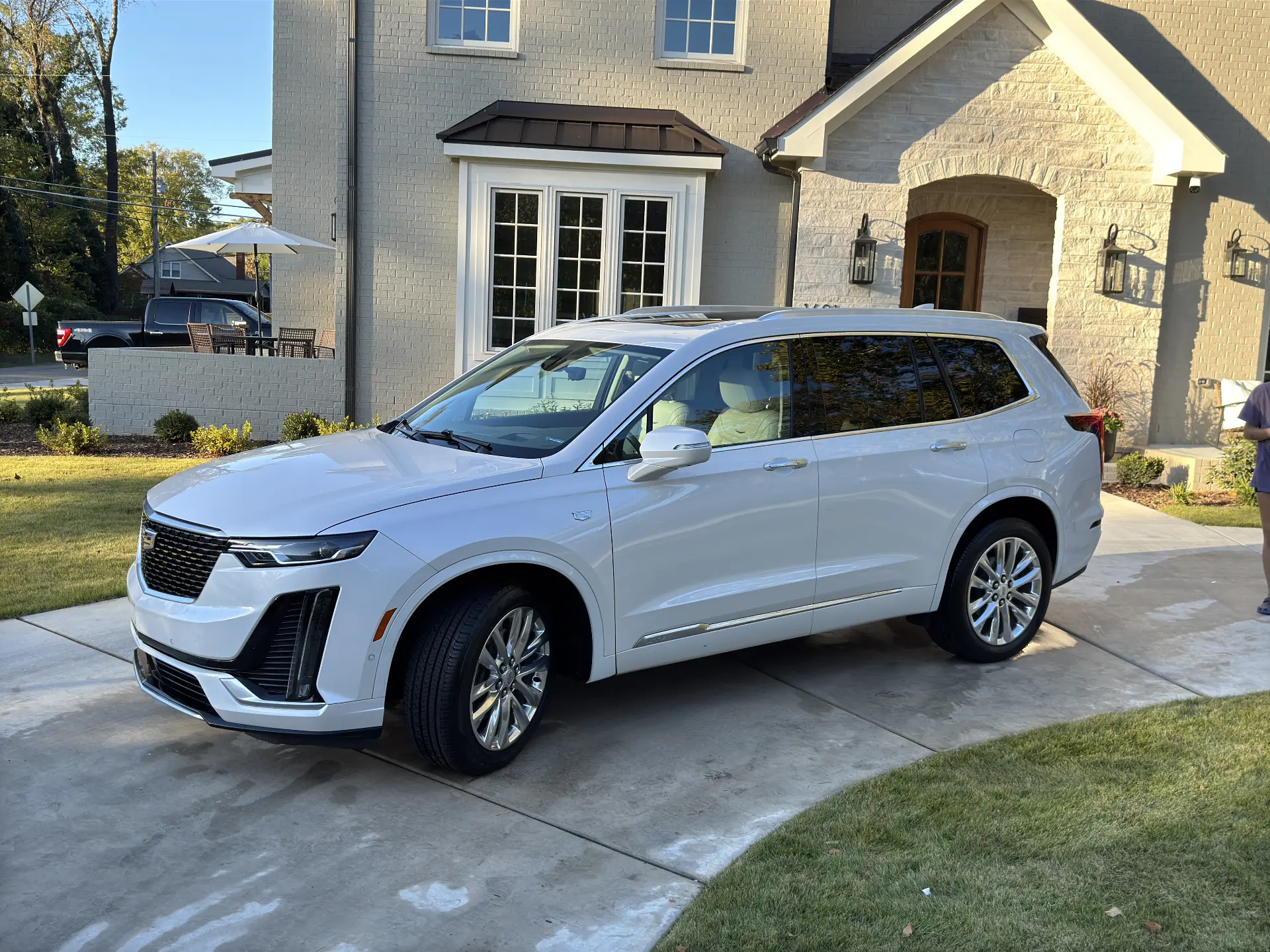 White Cadillac XT6 SUV detailed in the driveway of a brick home