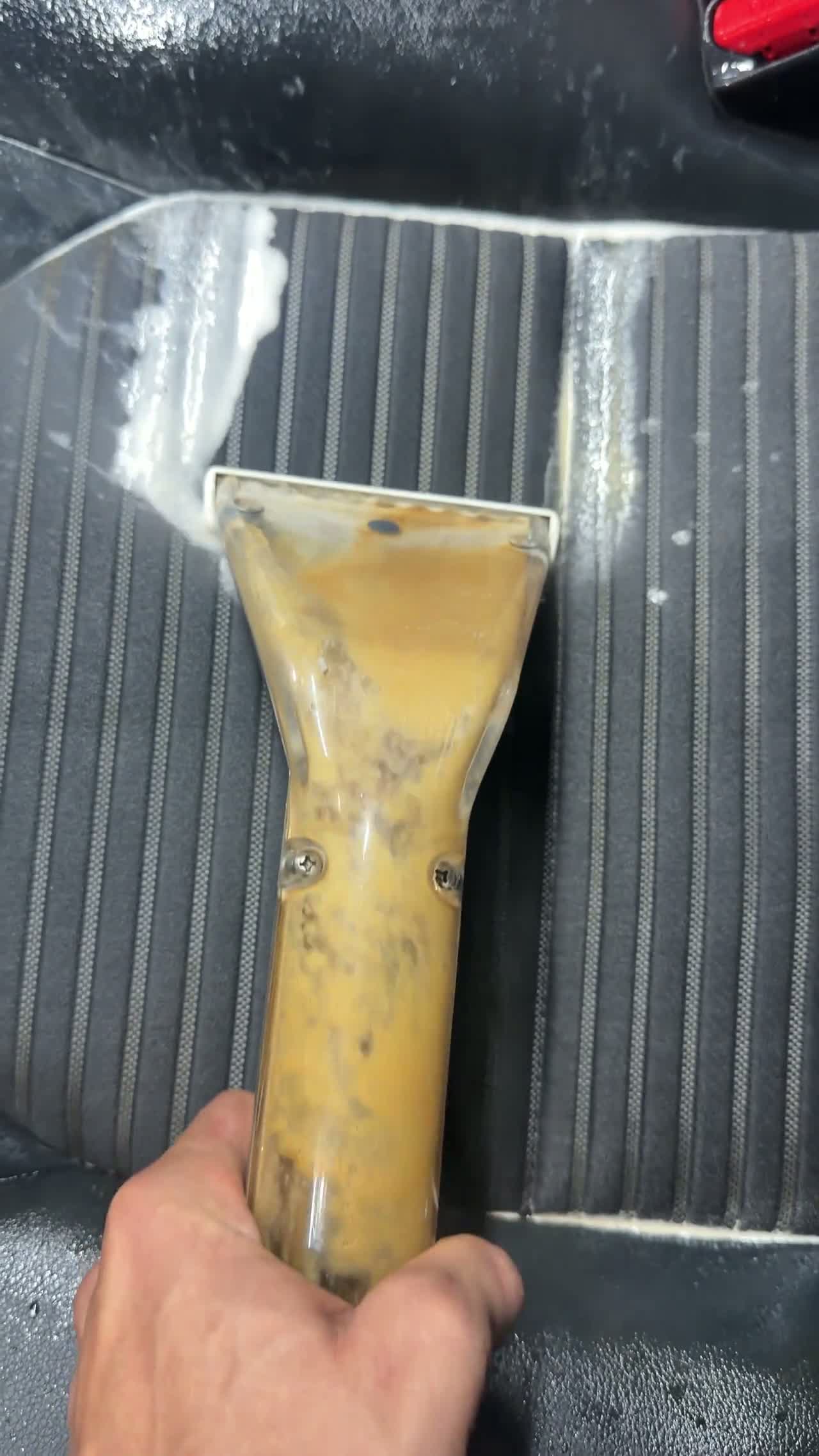 Hot water extraction lifting dirt from a cloth vehicle seat