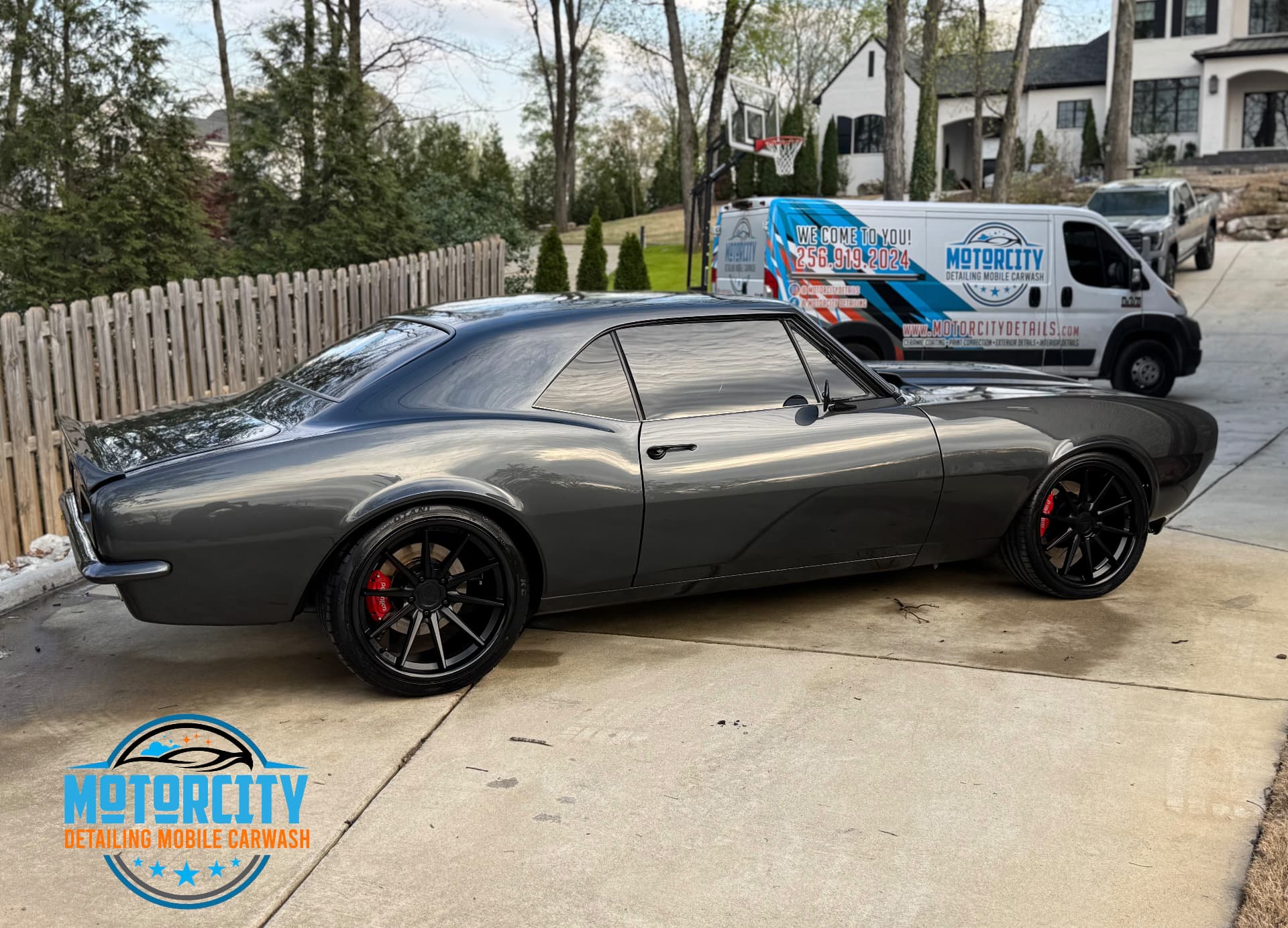 Grey classic Camaro washed in a driveway next to the Motorcity Detailing mobile van