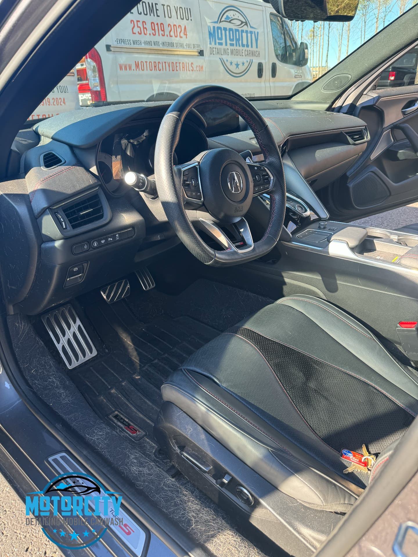 Cleaned Acura interior with the Motorcity Detailing van parked outside the open door
